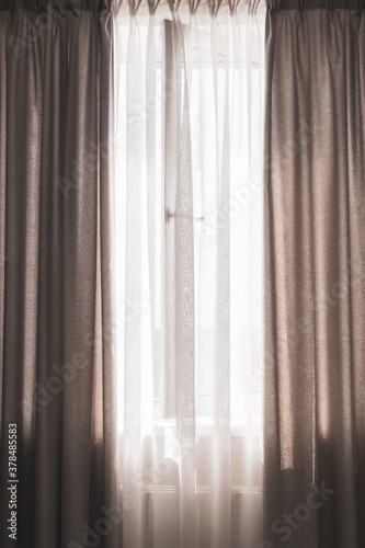 Window with curtains  vertical. Apartment design. Grey drapes with open window. Domestic interior. Modern home decoration. Open window with sunlight. 