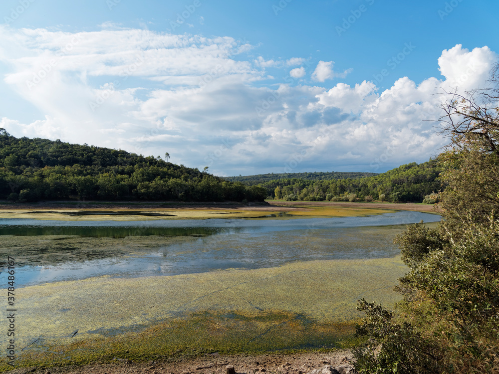 Colorful landscape of Carcès lake in Provence var with low water level, pumping water in september after a very hot and dry summer Colorful landscape of Carcès lake in Provence var with low water level, pumping water in september after a very hot and dry summer