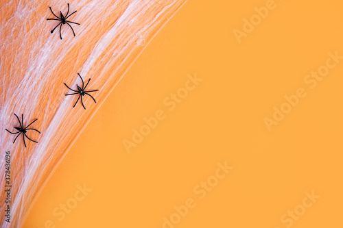 orange background for Halloween holiday with black spiders, copy space © Nastya