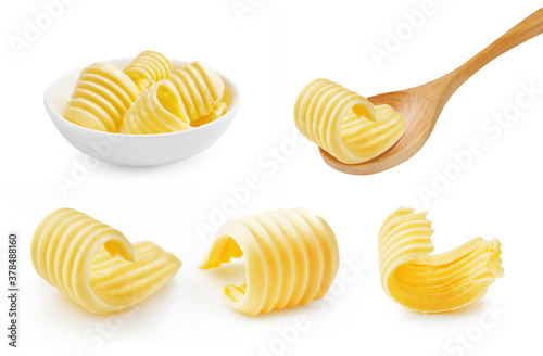 Set of butter curl on wooden spoon. Butter roll in white bowl isolated on white. photo