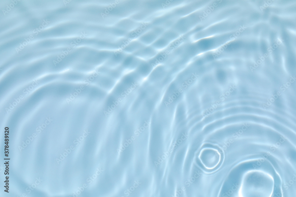de-focused. Blurred transparent blue colored clear calm water surface texture with splashes and bubbles. Trendy abstract nature background. Water waves in sunlight with copy space. de-focused. Blurred transparent blue colored clear calm water surface texture with splashes and bubbles. Trendy abstract nature background. Water waves in sunlight with copy space.