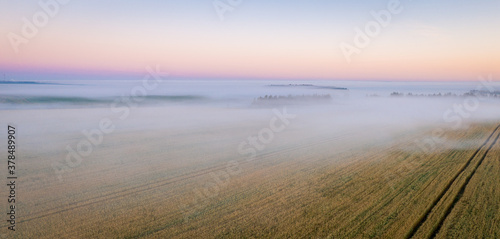 Morning fog in the meadows during sunrise in the countryside  aerial view height of the landscape on the horizon  a trees in the fog.