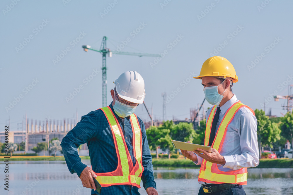 Businessman in medical mask talking on site construction by tablet technology Businessman in medical mask talking on site construction by tablet technology
