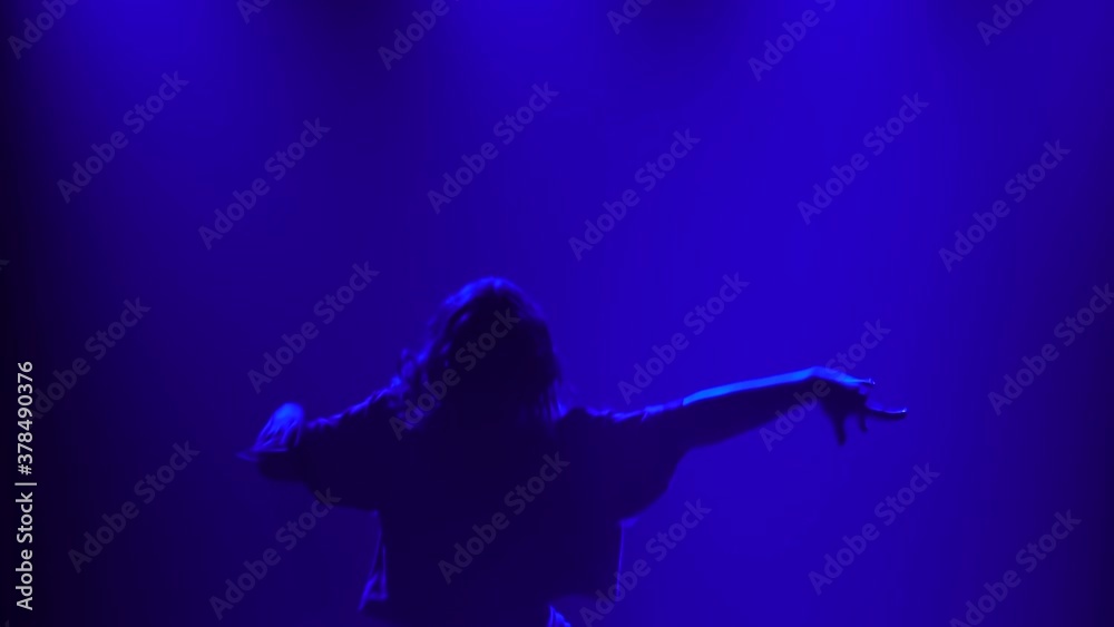 Young girl dancing in the studio modern choreography Jazz funk. A silhouette of a dancer on a smoky background with blue light. Close up. Young girl dancing in the studio modern choreography Jazz funk. A silhouette of a dancer on a smoky background with blue light. Close up.
