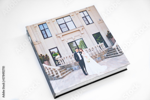 wedding photobook with thick pages on a white table. convenient, beautiful and long-lasting storage of photos from photo sessions. Russian names Artyom and Arina are written on the cover. photo