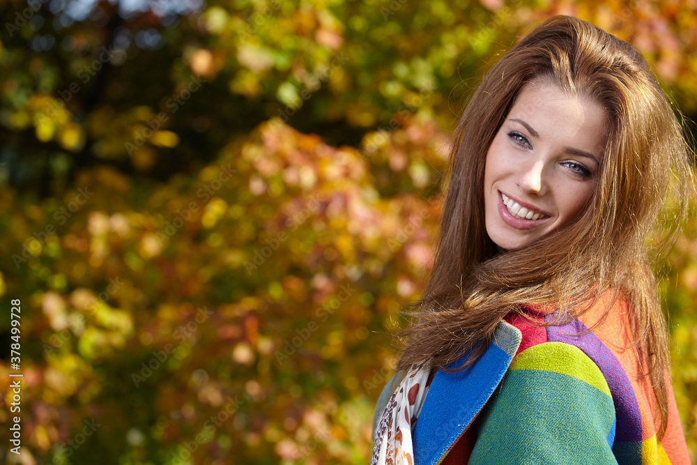 Beautiful elegant woman standing in a park in autumn Beautiful elegant woman standing in a park in autumn