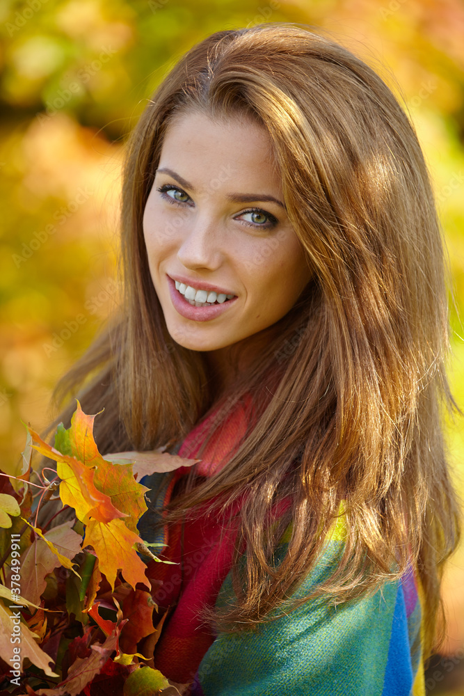 Beautiful elegant woman standing in a park in autumn Beautiful elegant woman standing in a park in autumn