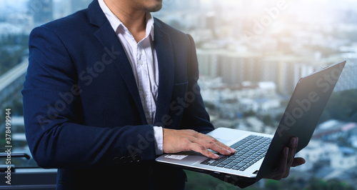 business man using laptop background with city.