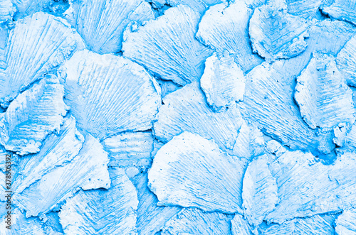 The background is light blue. Abstract drawing made of concrete, made on the wall with special tools. Texture. The decorative surface in the form of petals is made of cement. Light blue pattern.