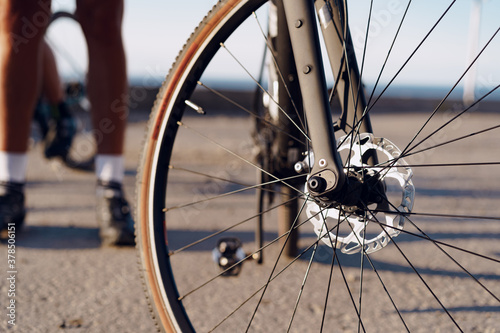 Cyclist man feet and bike wheel on coastal road