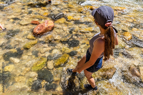 Fototapeta Naklejka Na Ścianę i Meble -  Teenage girl wading in the river, feet wet in Zion National Park, Utah, USA