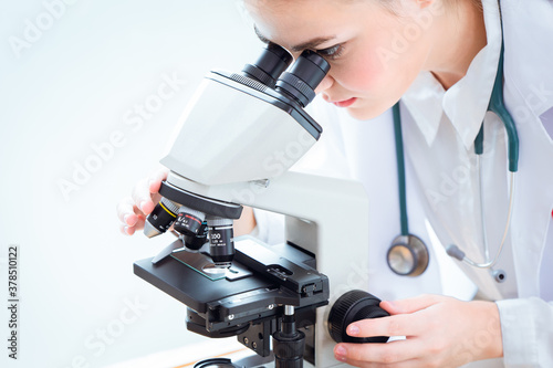 Scientist looking at microscope in science laboratory for virus research in laboratory.