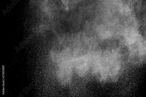 Freeze motion of white particles on black background. Powder explosion. Abstract dust overlay texture.