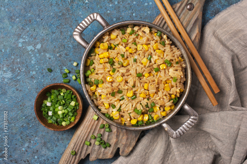 A traditional vegetarian dish of Asian cuisine. Rice with green onion and yellow corn