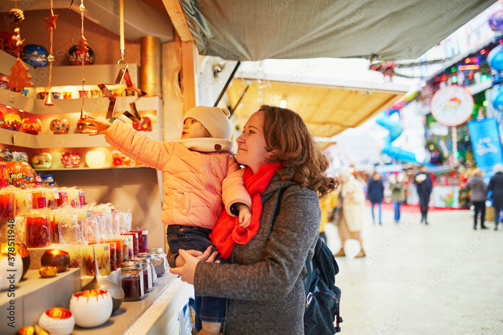 Woman and adorable toddler girl on Christmas market in Paris, France Woman and adorable toddler girl on Christmas market in Paris, France