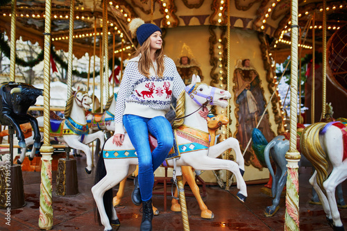Canvas-taulu Beautiful young woman riding a horse on merry-go-round on traditional Christmas