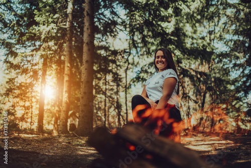 Fototapeta Naklejka Na Ścianę i Meble -  young woman enjoying nature, picnicking in nature, walking in the forest enjoying the sunset