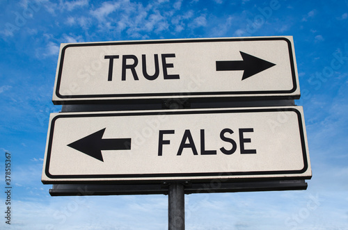 True vs false. White two street signs with arrow on metal pole with word. Directional road. Crossroads Road Sign, Two Arrow. Blue sky background. Two way road sign with text.