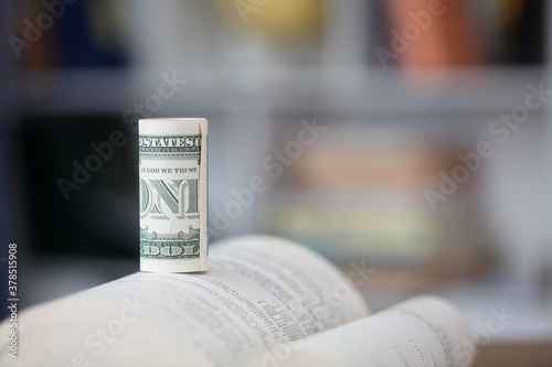 A book and a roll of dollar bills