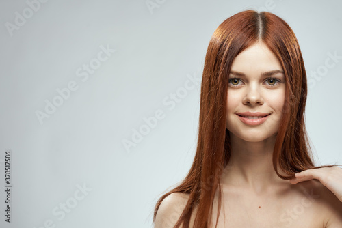 beautiful red-haired woman naked shoulders cosmetics long hair glamor light background