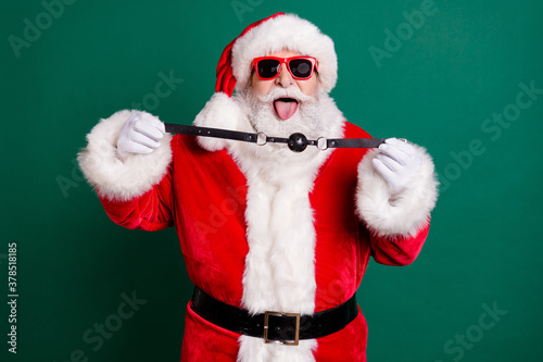 Photo of naughty crazy santa claus show tongue-out deliver x-mas christmas night midnight present woman hold leather gag wear red costume headwear isolated over green color background photo
