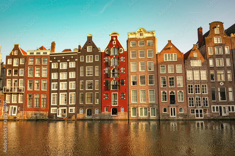 Tipical buildings and canals with blue sky in Amsterdam Holland