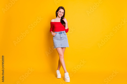 Full length body size view of her she nice attractive lovely winsome cute cheerful brown-haired girl posing caressing hair isolated over bright vivid shine vibrant yellow color background