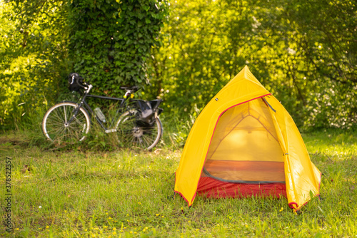 Image of small tent at a park with touring bicycle at the background