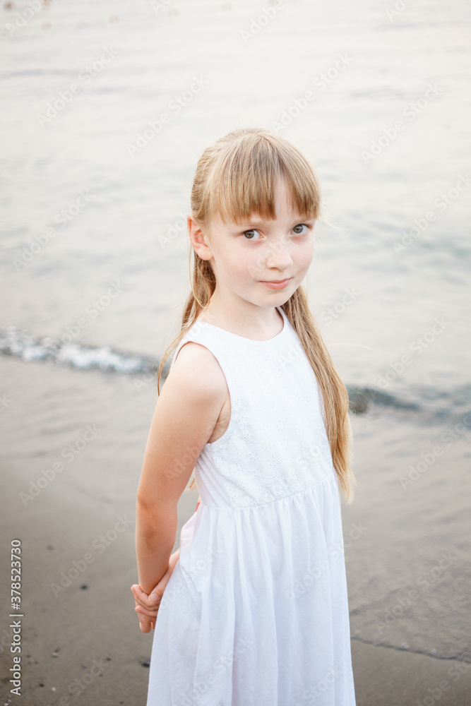 blonde girl in a white dress resting by the sea blonde girl in a white dress resting by the sea