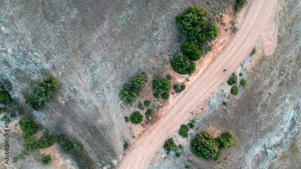 A cyclist going up a dirt road, seen from a drone. Along the way you can see the old Solera de Gabaldón cemetery. A cyclist going up a dirt road, seen from a drone. Along the way you can see the old Solera de Gabaldón cemetery.