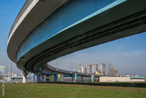 Urban landscape with a curved overpass and a residential complex under construction in the background