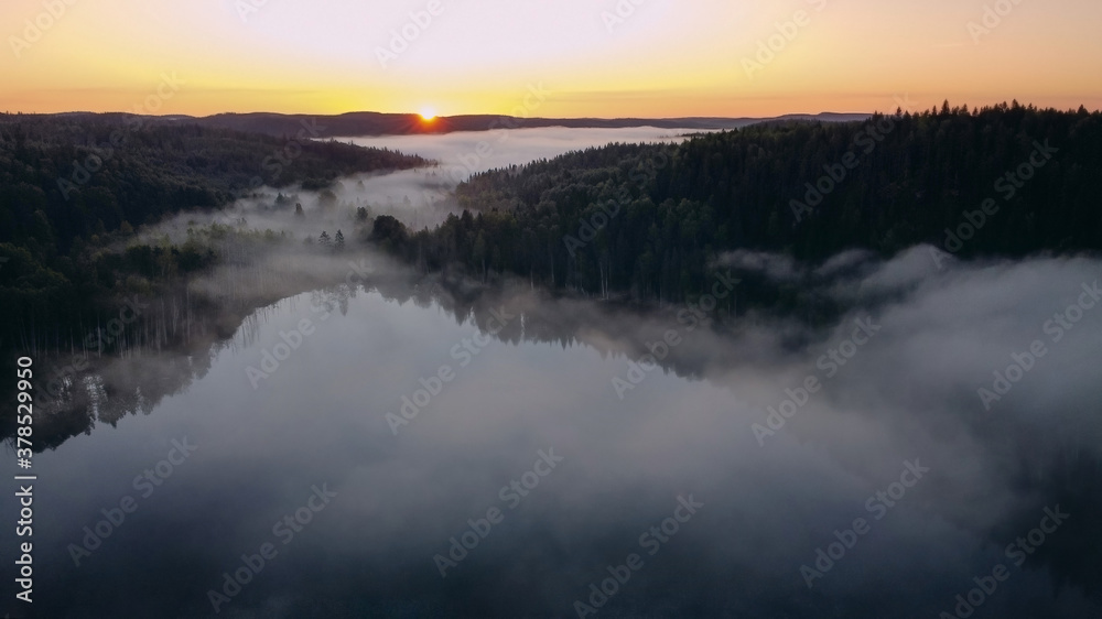 Sunrise on the lake with fog. Panorama view from a height of flight on a drone.