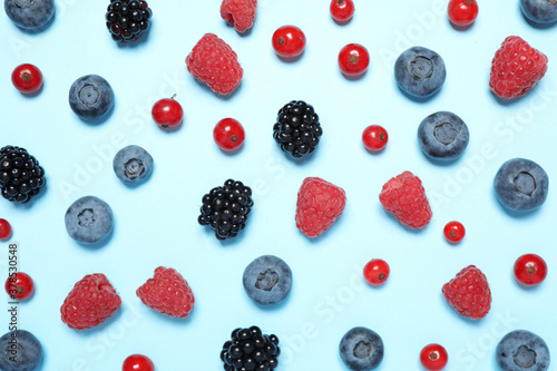Different fresh berries on light blue background, flat lay