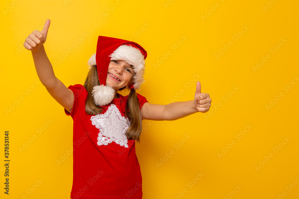 Little girl wearing Santa hat holding thumbs up Little girl wearing Santa hat holding thumbs up