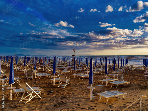 Empty umbrellas at sunset on the beach of Marina di Castagneto Carducci Tuscany Italy © Paolo Borella