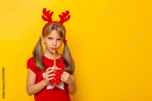 Child wearing deer antlers costume drinking juice