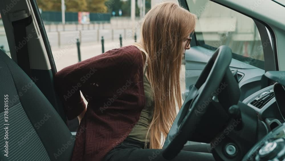 Young disabled woman getting out from the car in her wheelchair. . High quality 4k footage