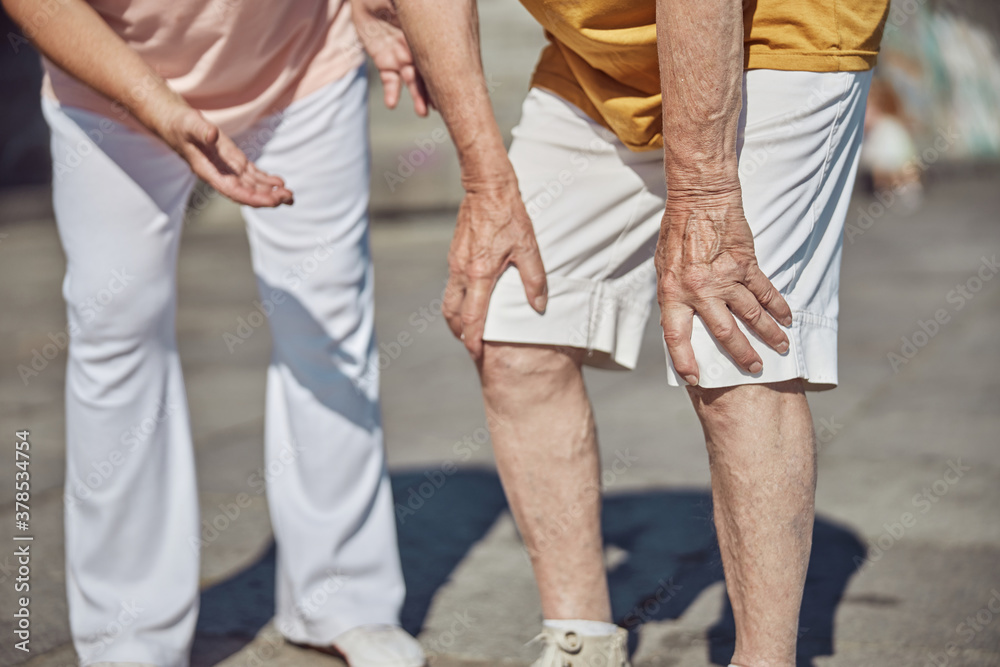 Senior man touching his knees with hands