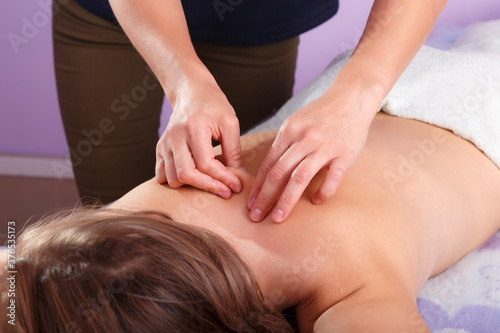 Hands of massage therapist on a back of a client