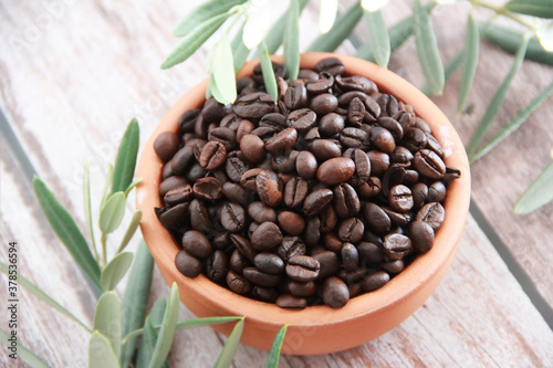 natural black coffee beans in a ceramic plate