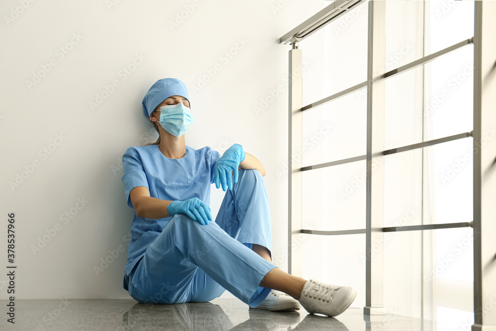 Exhausted doctor indoors. Stress of health care workers during COVID-19 pandemic Exhausted doctor indoors. Stress of health care workers during COVID-19 pandemic