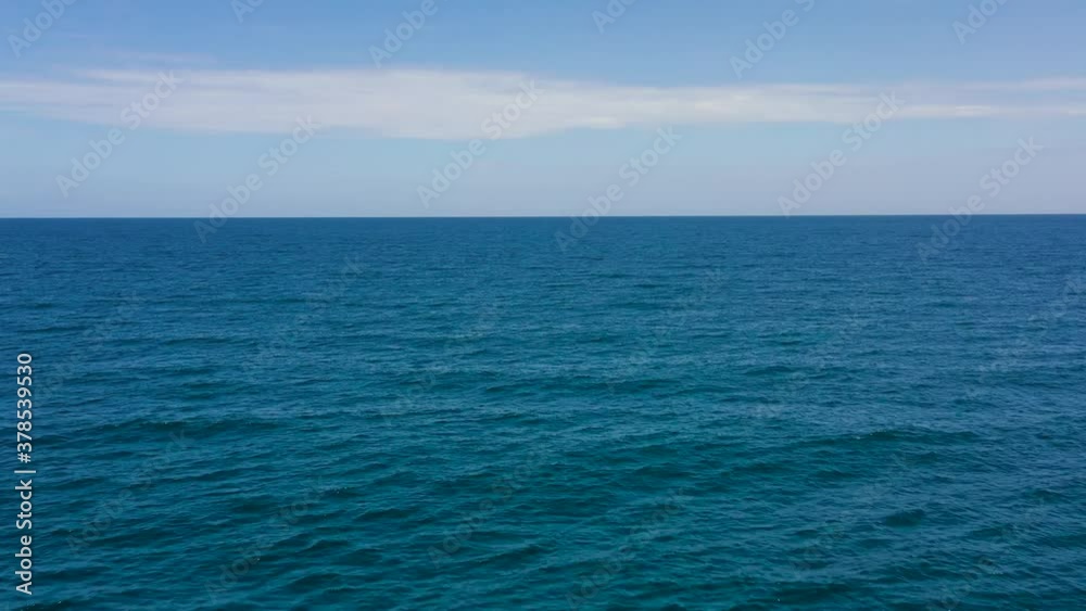 Aerial seascape: The surface of the blue sea against a blue sky with clouds. Aerial seascape: The surface of the blue sea against a blue sky with clouds.