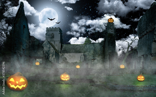 Eerie Halloween pumpkins lit up in front of an old ruined castle © Jens Rother