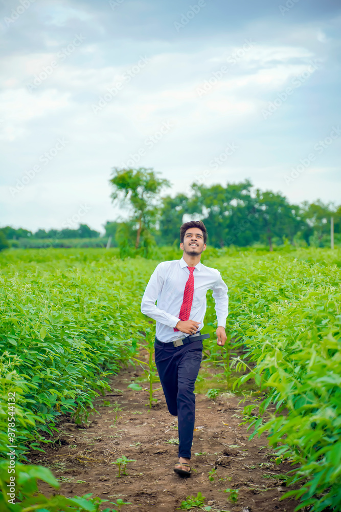 Fototapeta premium Young asian / Indian man running at agriculture field