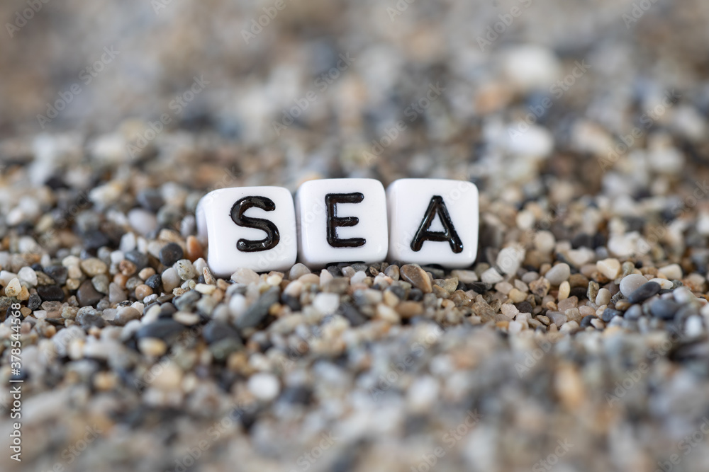 Sea inscription text in a still life of the letters layed out on a shore sand stones. Sea inscription text in a still life of the letters layed out on a shore sand stones.