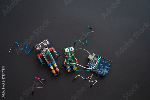 A metal robot and an electronic board that can be programmed. Robotics and electronics. DIY robotics. STEM and STEAM education for kids. Free space for text.