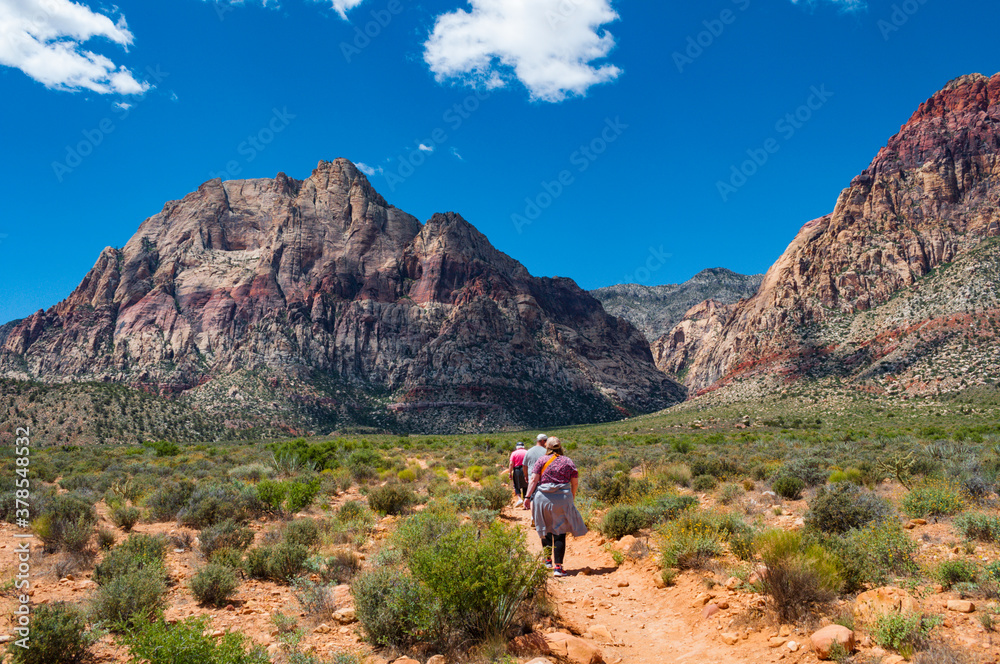 A small group of day hikers follow the trail towards the mountain range at Red Rock Canyon outside Las Vegas NV