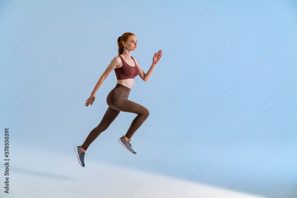 Photo of athletic focused sportswoman running while working out Photo of athletic focused sportswoman running while working out