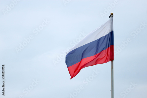 Waiving flag of Russian federation on cloudy sky background closeup