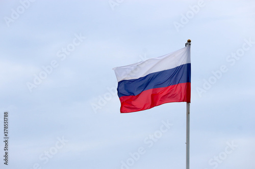 Waiving flag of Russian federation on cloudy sky background closeup